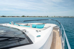 Yacht deck with seating area and mint blue turquoise cushions on a clear day.