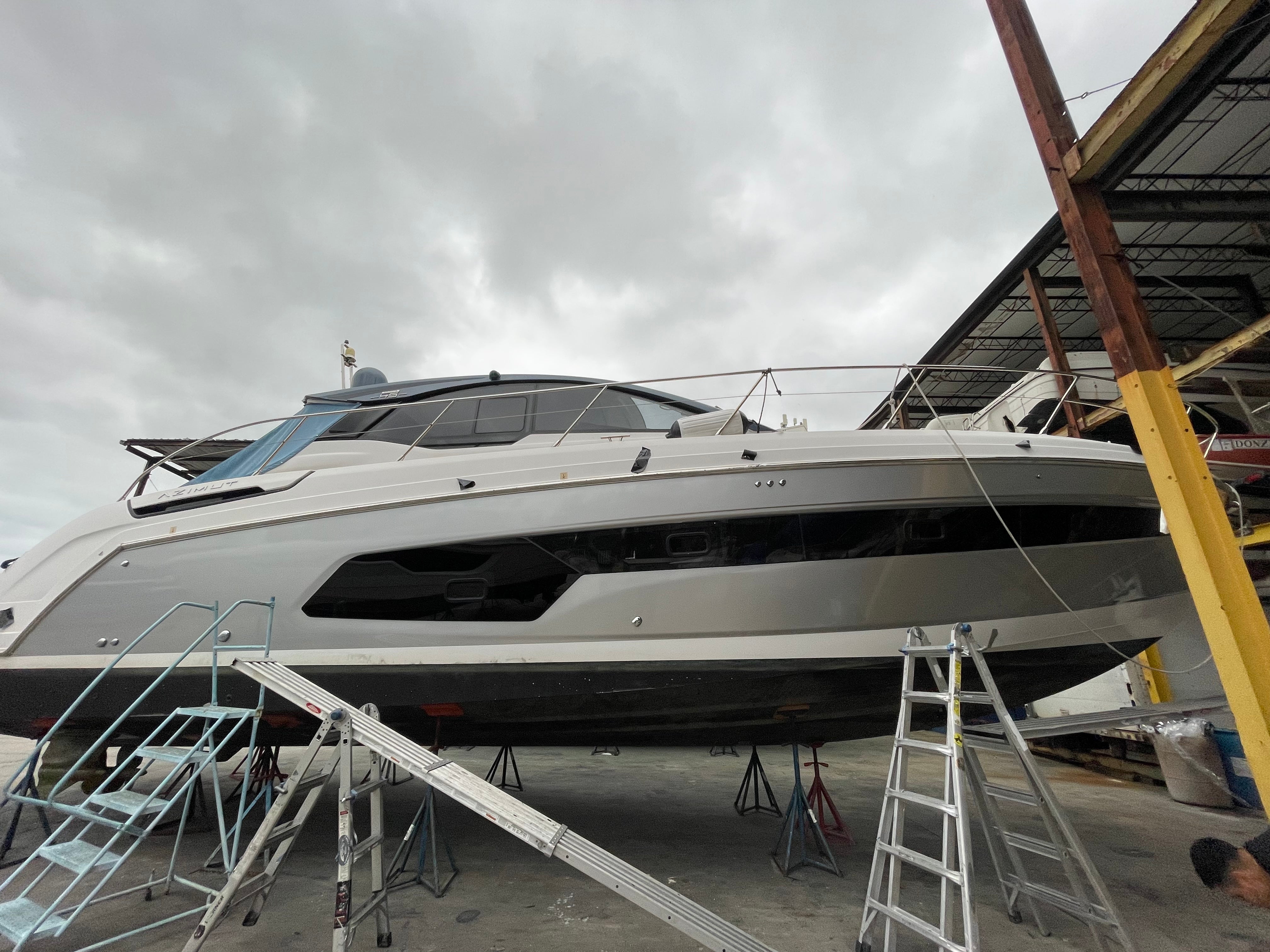 Yacht inside a warehouse with visible branding on the side.
