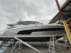Yacht inside a warehouse with visible branding on the side.